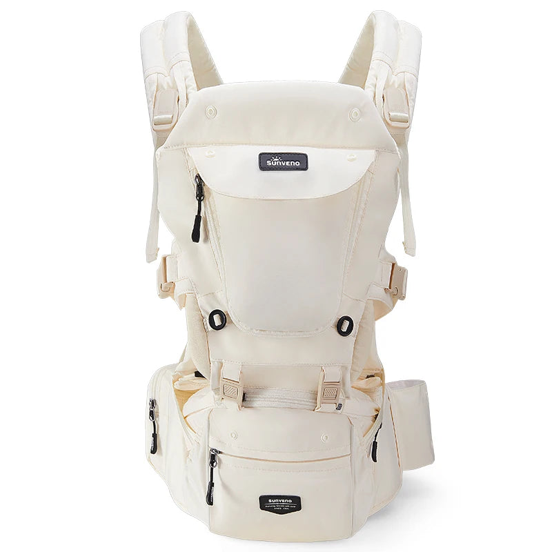 Parent portant son bébé avec le porte-bébé Ergobloom en position face au porteur, dans un parc ensoleillé