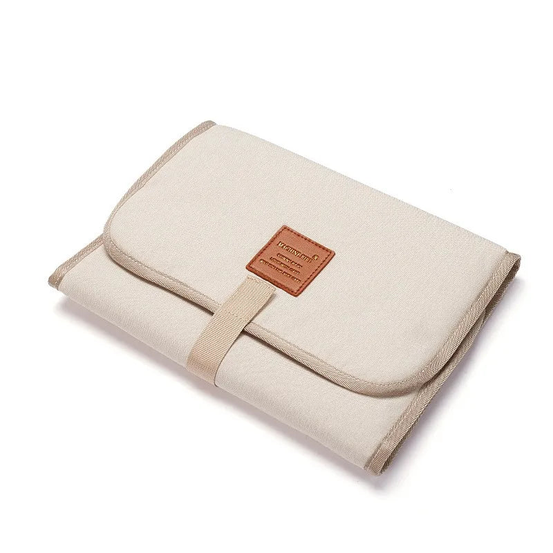Matelas à langer en nylon et PEVA, imperméable, dimensions fermé 31x21x1,5 cm, dimensions ouvert 58x30x1 cm, facile à nettoyer avec un chiffon microfibre humide beige