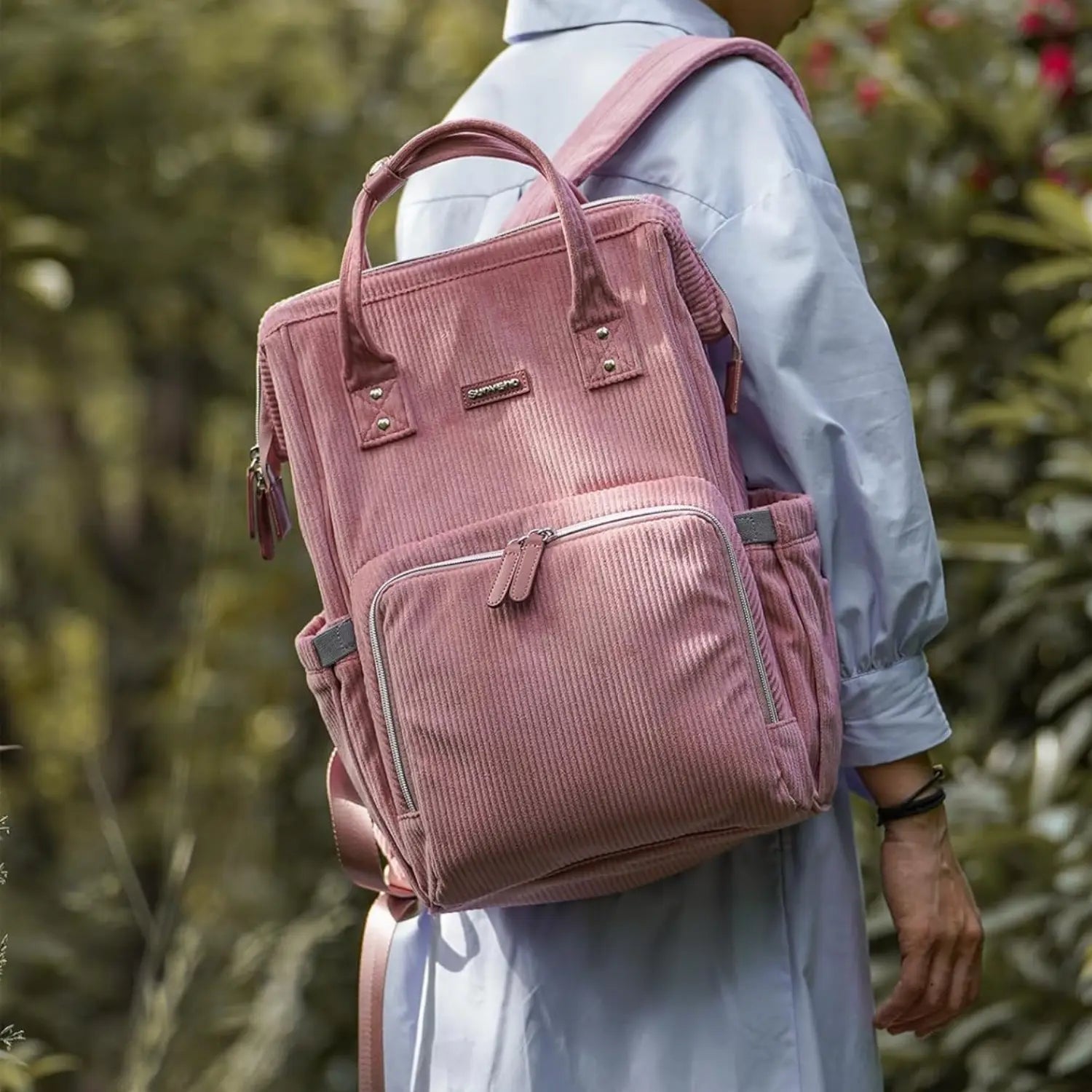 sac à dos sac à langer rose Goodnvibes porté par un parent – design premium, compartiments astucieux et grande contenance pour une utilisation polyvalente.