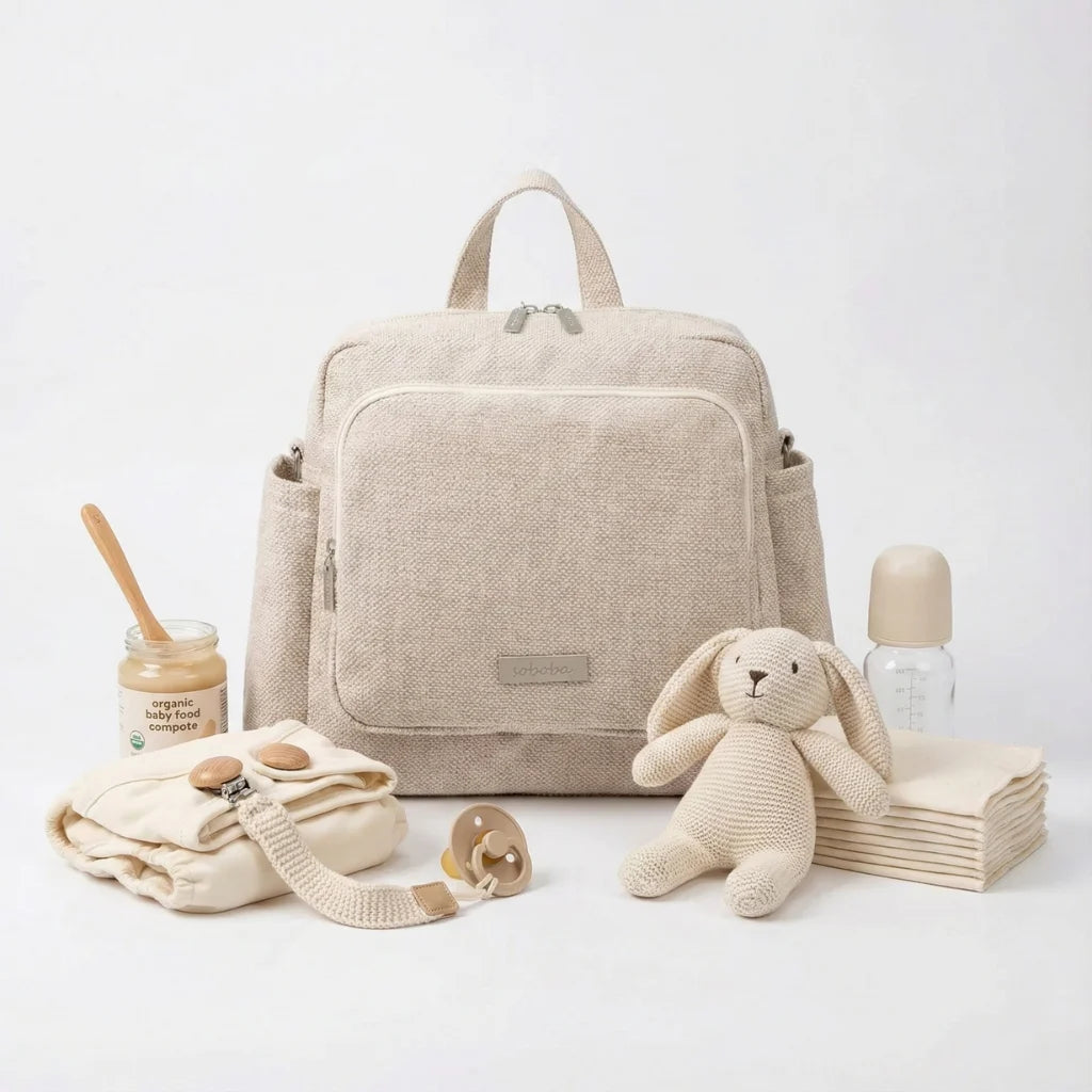 Ce sac à langer compact séduit par son design soigné en PU effet cuir, subtilement contrasté par deux empiècements en tissu texturé façon lin.