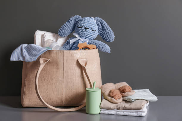 Maman comparant différents sacs à langer modernes pour bébé, entre sac à dos et modèle bandoulière