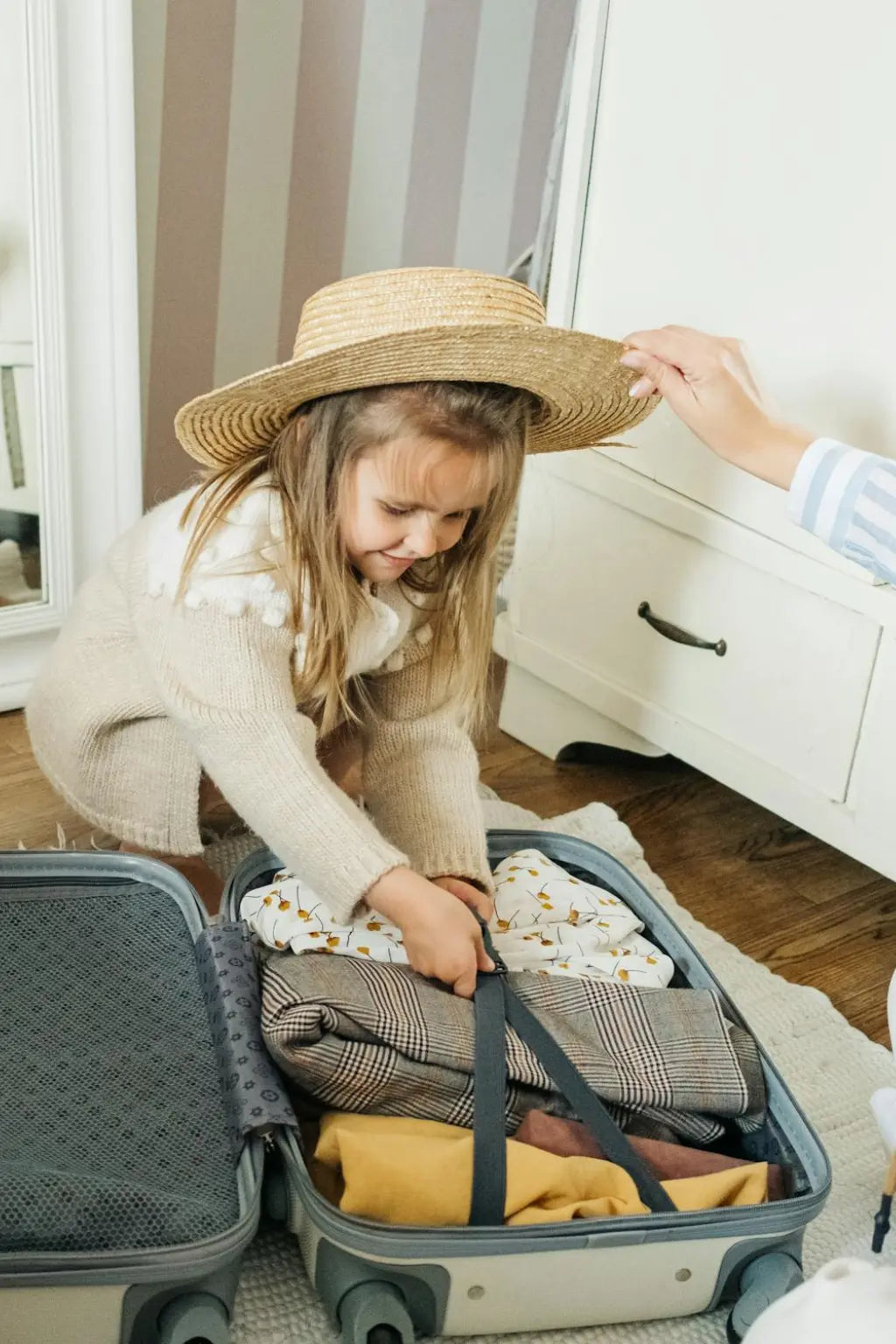 Maman et enfant préparant ensemble la valise de maternité – anticipation de l’arrivée de bébé en famille