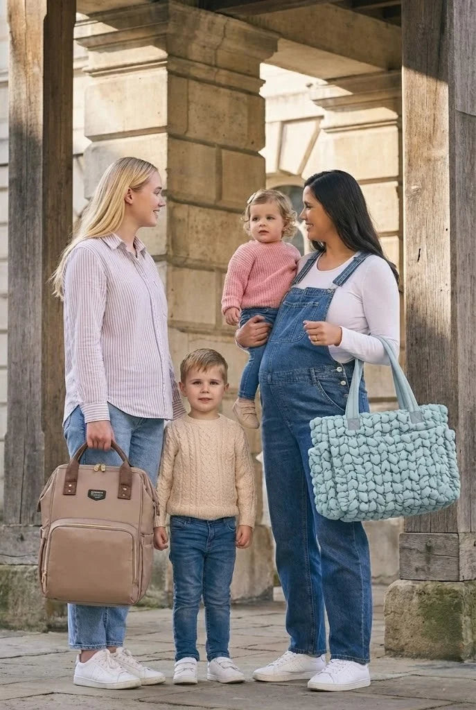 Sacs à langer Goodnvibes portés par deux mamans à Paris : sac à dos beige pratique et grand sac maternité bleu texturé en promenade familiale devant la Tour Eiffel.