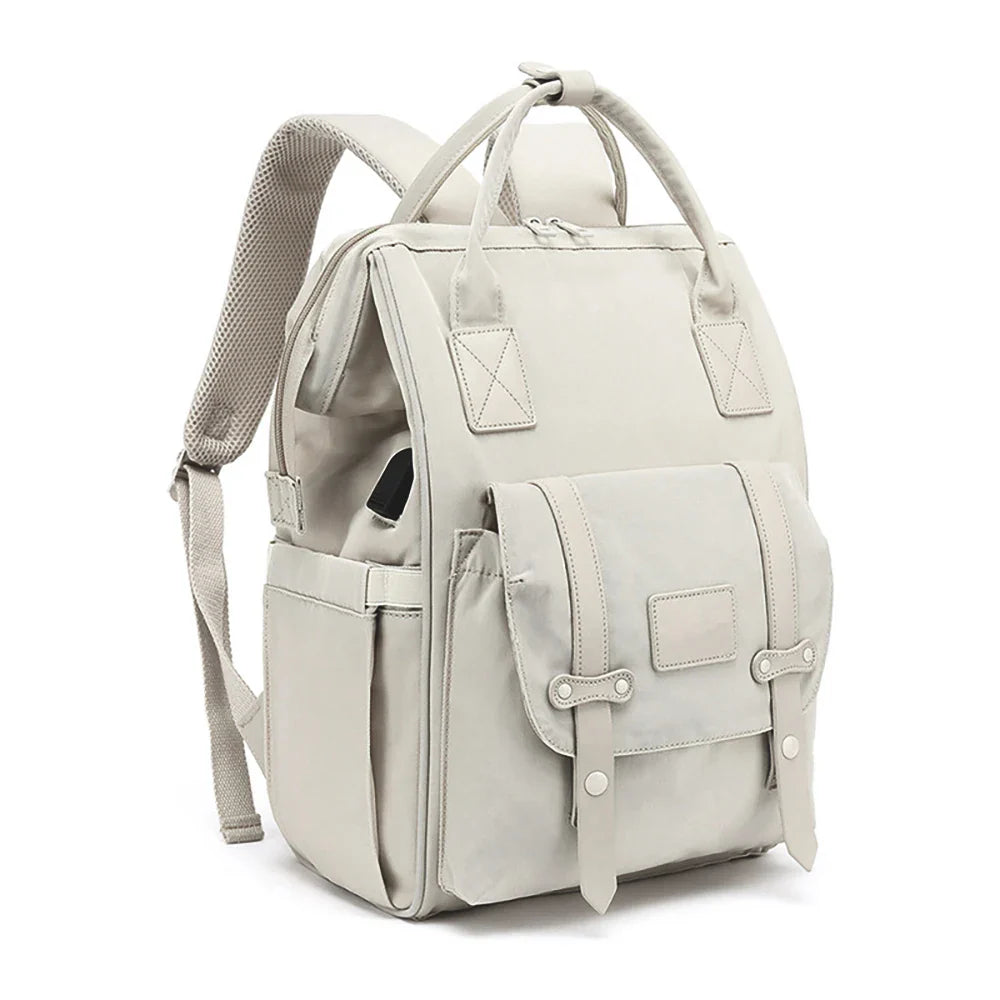 Sac à langer Travel posé à côté d’une poussette, accessoire pratique pour sorties en famille
