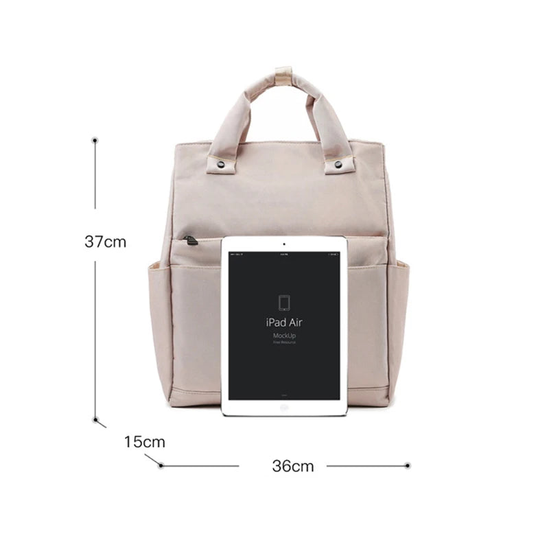 Sac à langer beige posé sur une poussette, vue d’ensemble
