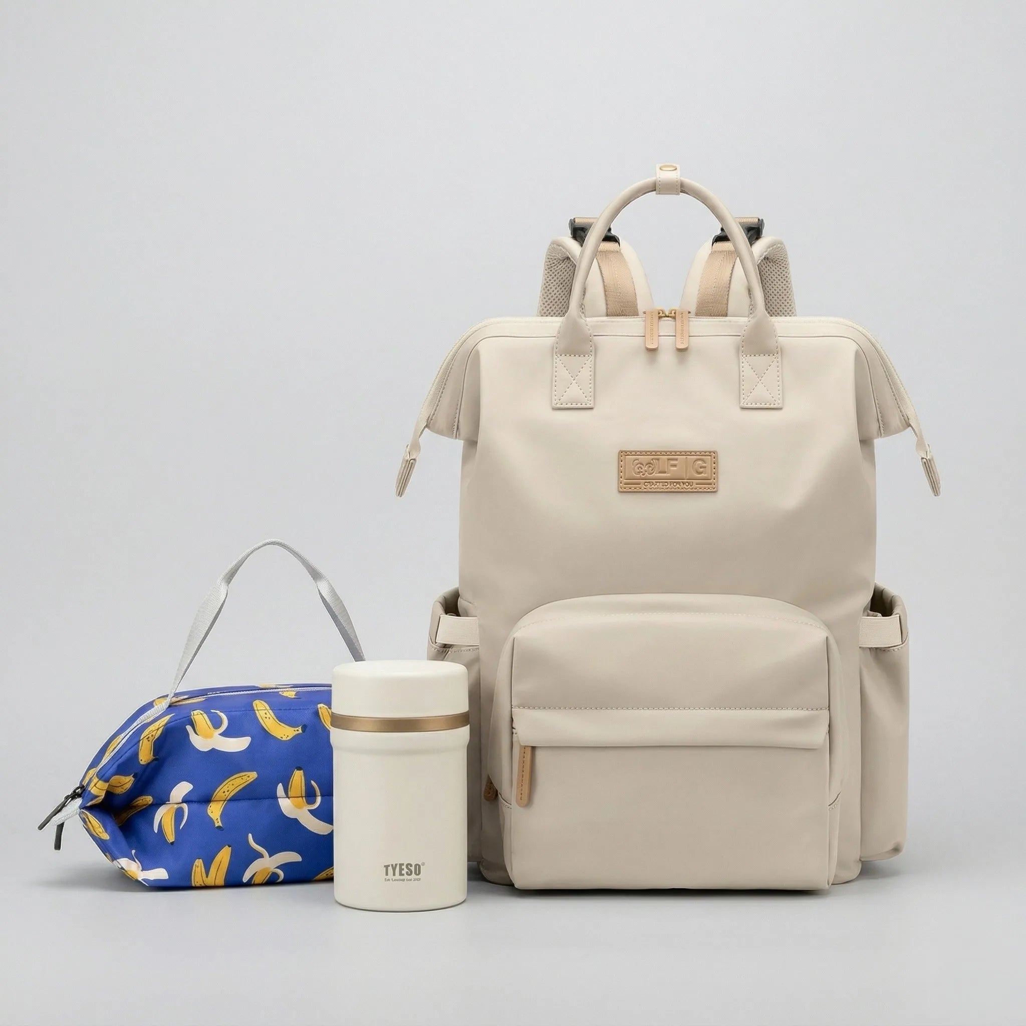 Solution pour parents actifs avec le sac à dos à langer Nyla beige, le lunch bag isotherme grande capacité FreshBox banane et la lunch box isotherme blanche.