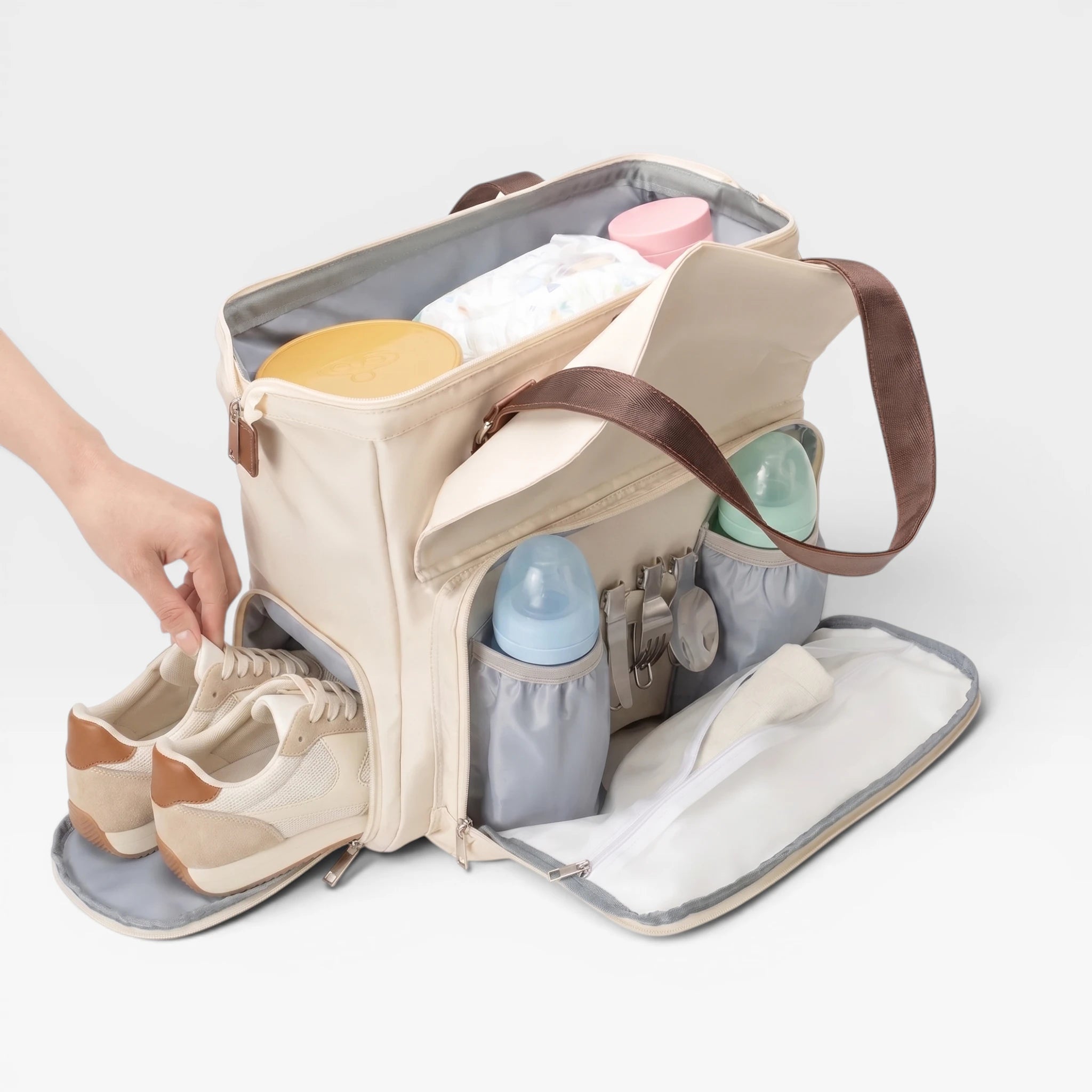 Vue intérieure du sac à langer Aventure montrant les compartiments intelligents de rangement et les poches isothermes pour biberons.