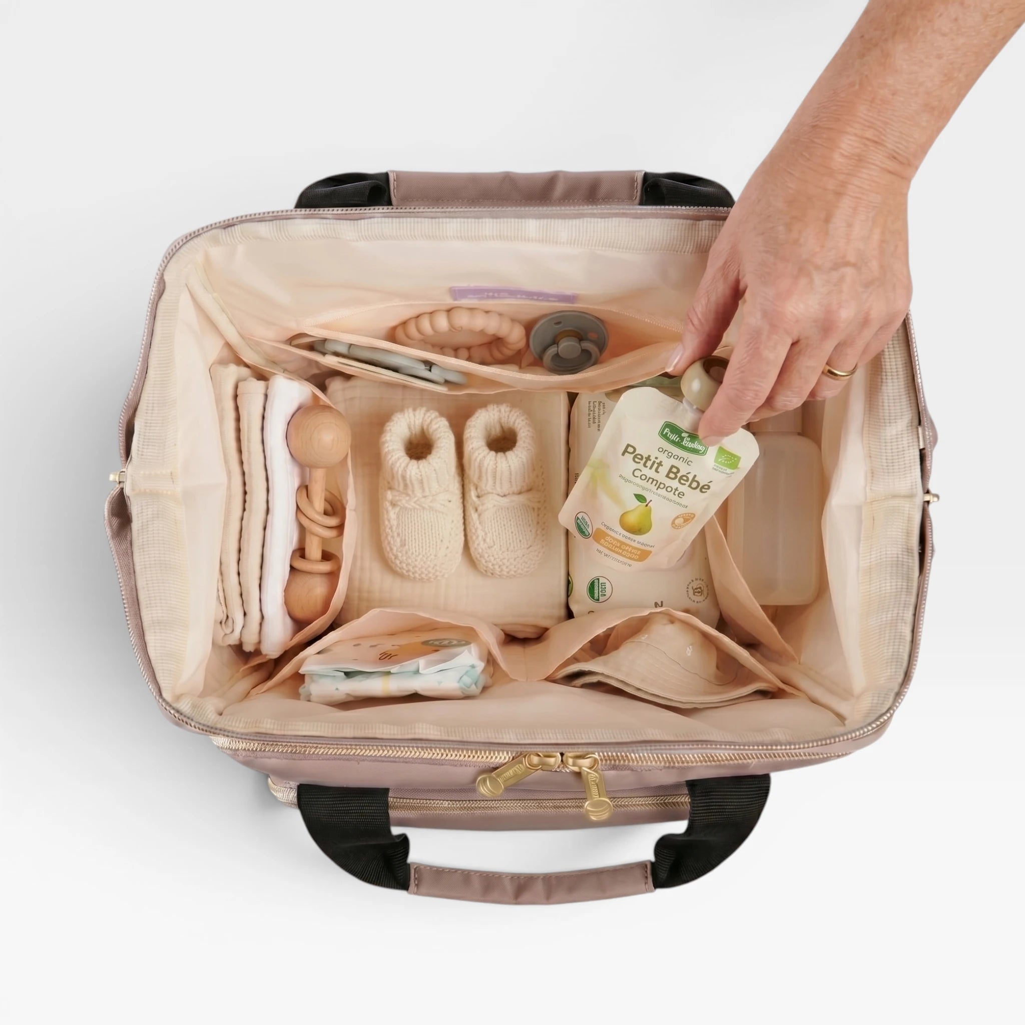 Vue intérieure du sac à langer Moka ouvert type médecin montrant les poches de rangement, compartiments biberons et tapis à langer.