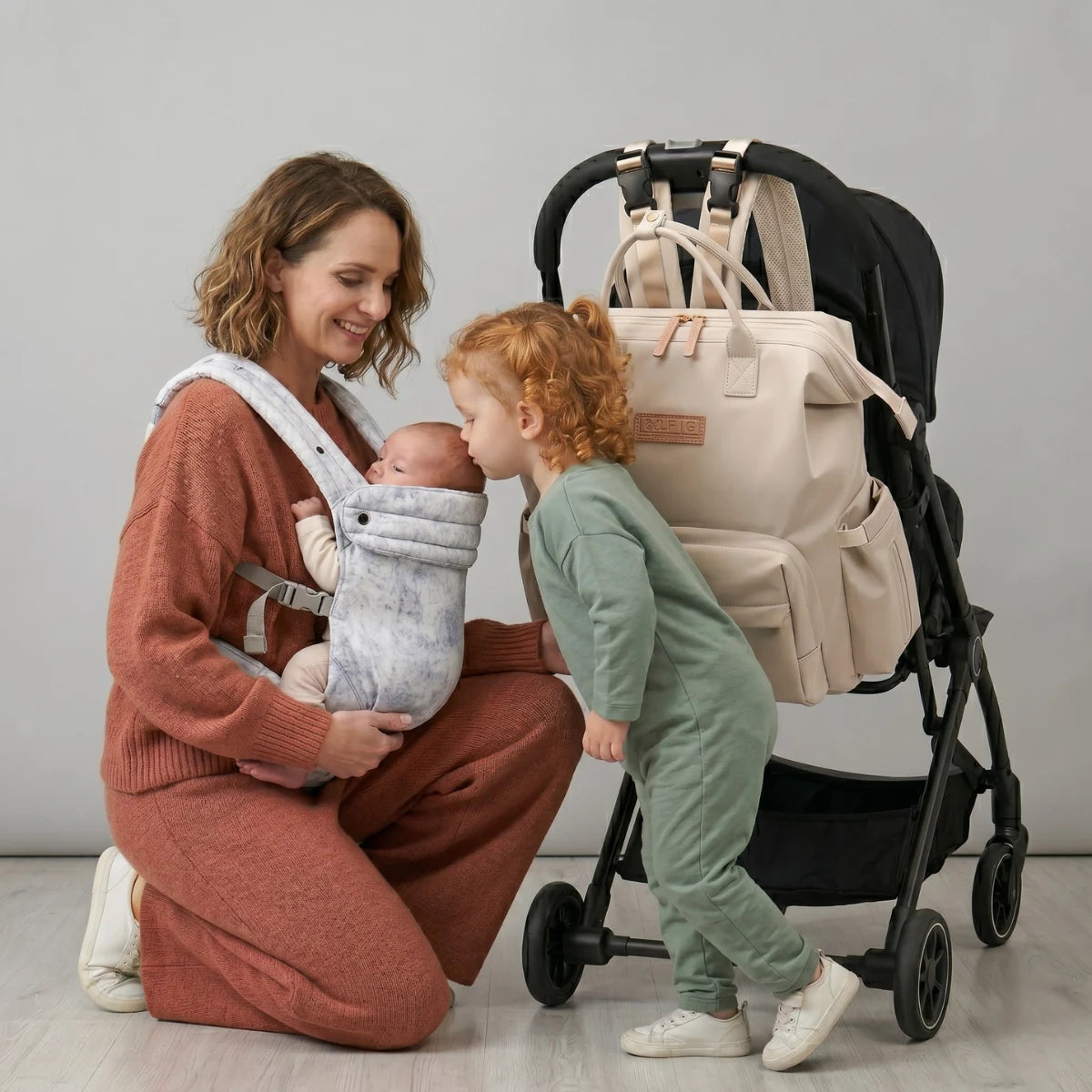 Moment de complicité entre une maman et sa fille en studio avec le sac Nyla attaché à la poussette.