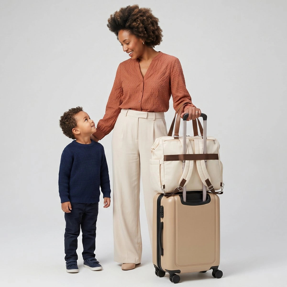 Sac à langer de voyage Aventure fixé sur une valise cabine avec sa sangle trolley pour faciliter les déplacements avec bébé