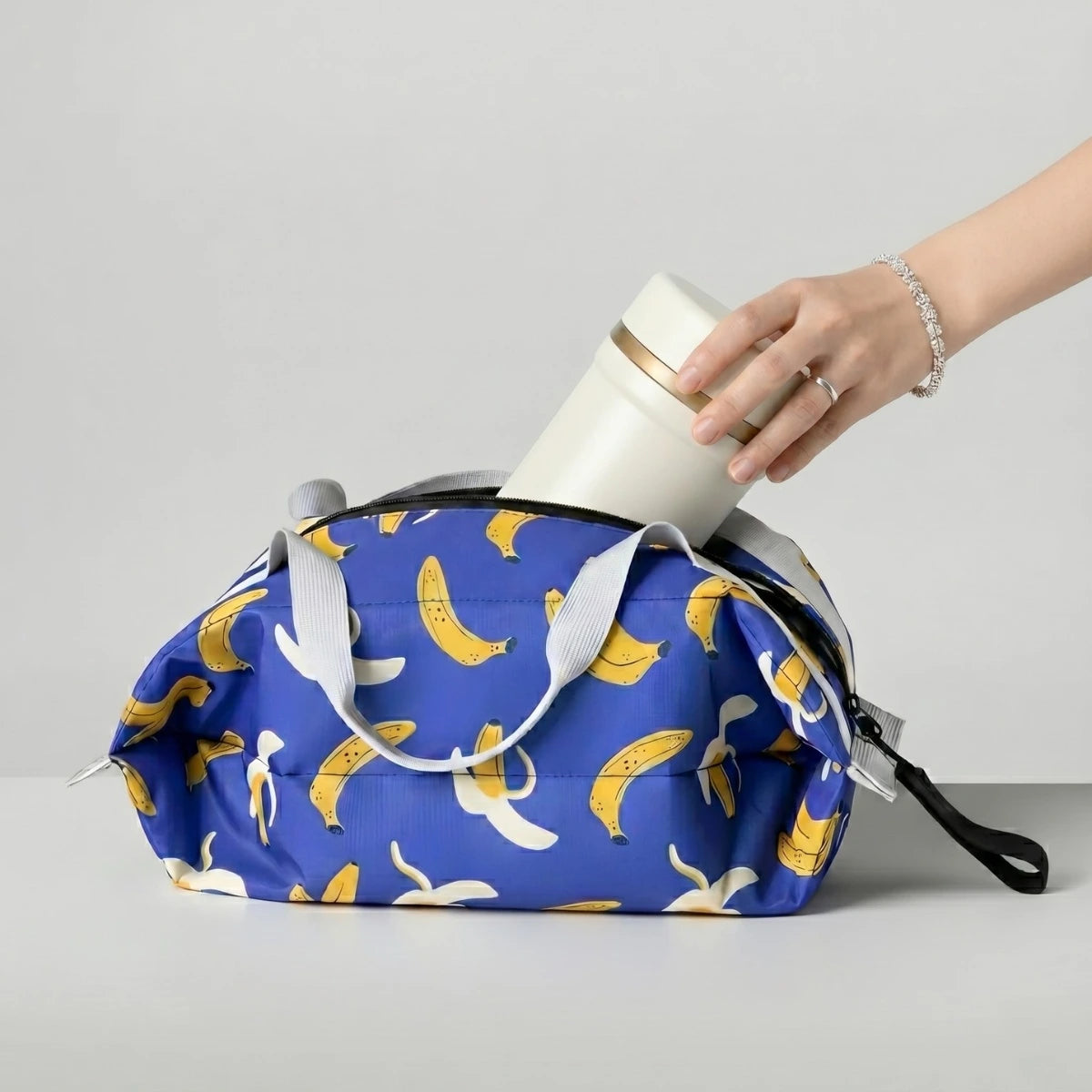 Sac isotherme repas déperlant motif banane ouvert avec lunch box blanche 600ml pour déjeuner nomade.